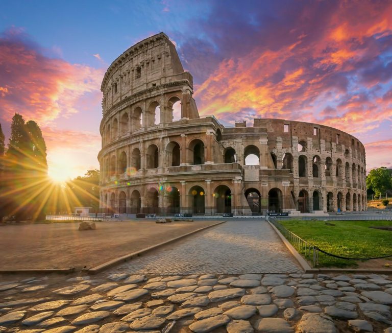 Le Colisée de Rome au coucher du soleil, éclairé par des couleurs vives.